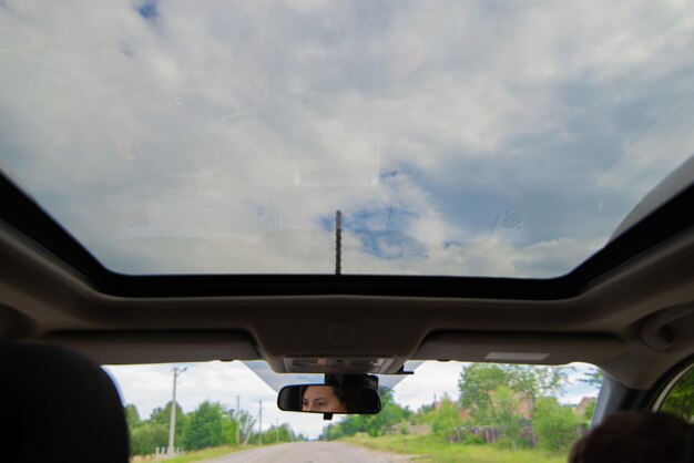 Femme conducteur de voiture yeux reflet dans l'espace de copie de toit ouvrant miroir