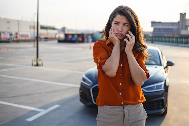 femme conductrice utilisant un téléphone portable pendant une panne de voiture à problème ou une voiture cassée sur la route Concept d'entretien et de service d'assurance véhicule
