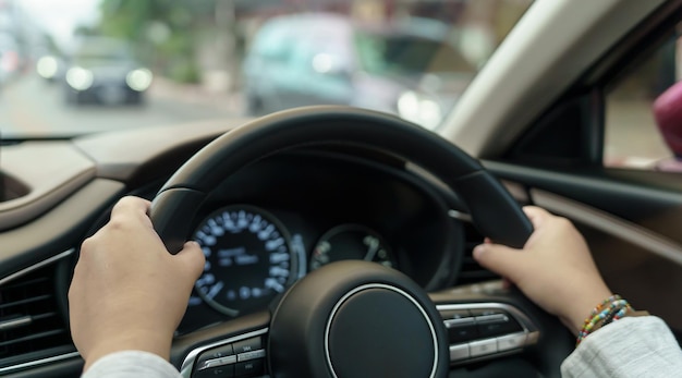 Femme conduisant une voiture fille se sentant heureuse de conduire en tenant le volant et en regardant sur la route