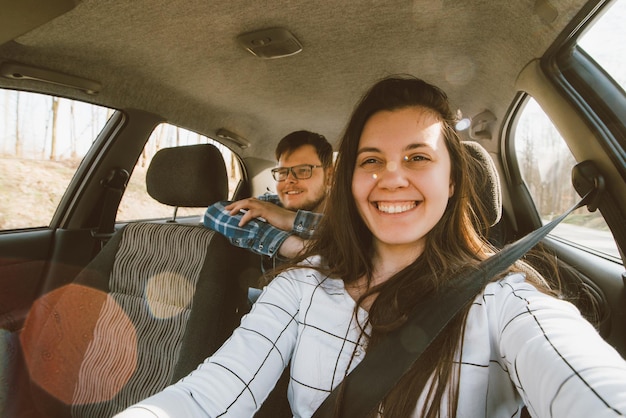 Femme conduisant une voiture homme assis à l'arrière en tant que passager