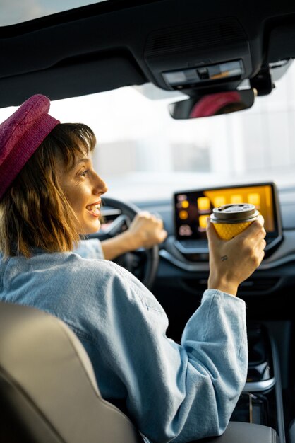 Photo une femme conduit une voiture avec un café.