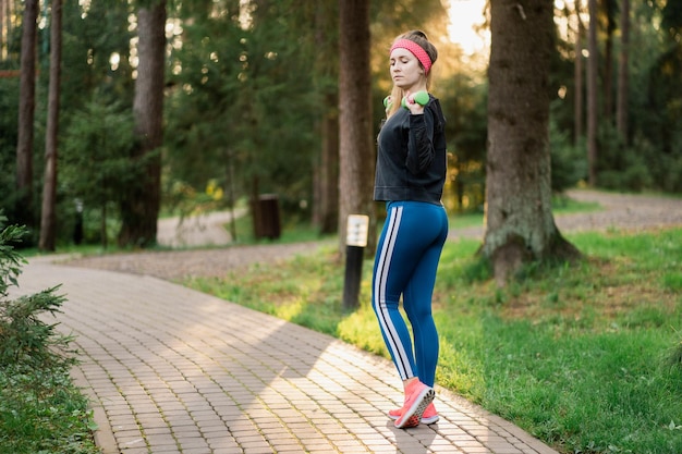 Femme confiante d'athlète d'apparence caucasienne faisant des exercices d'entraînement matinal dans le