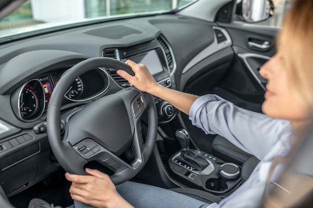 Femme confiante conduisant en voiture pendant la journée