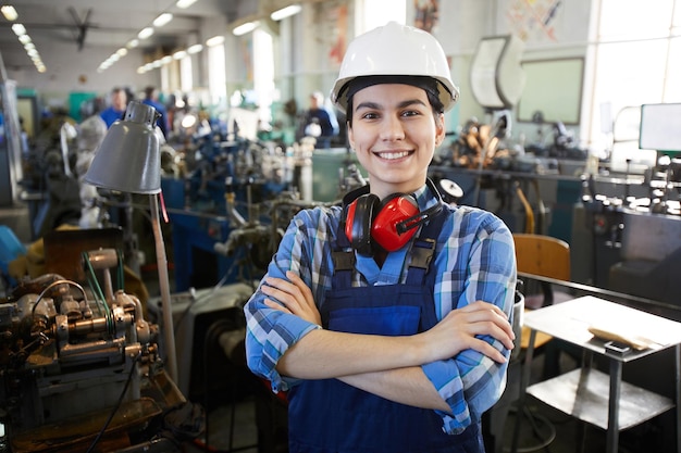 Femme confiante gaie à l'usine d'horloge