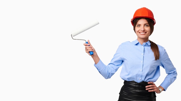 Femme confiante souriante en casque tenant le rouleau sur blanc isolé