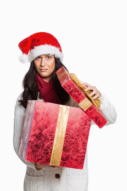 Femme confuse ouvrant le cadeau de Noël