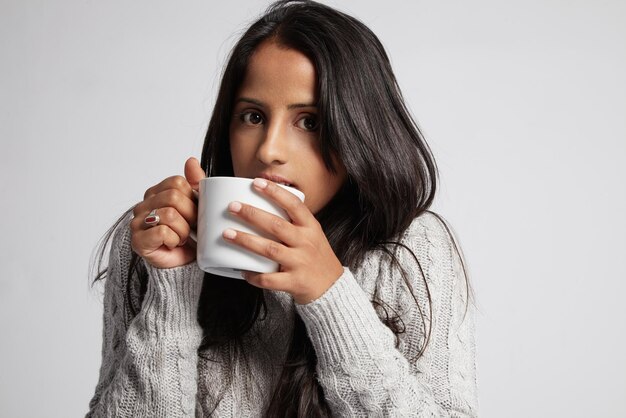 Une femme congelée boit un tee-shirt chaud porte un pull en tricot