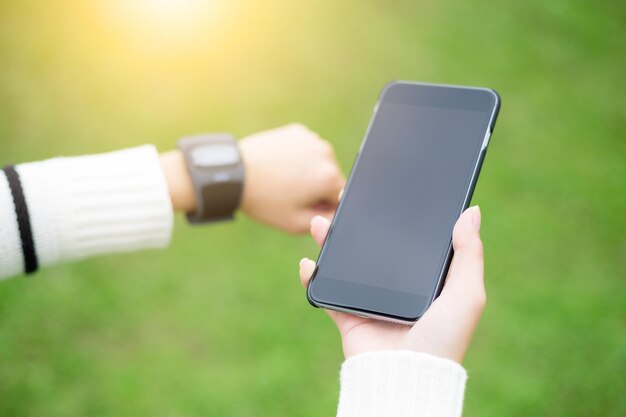 Femme connectant montre et téléphone portable