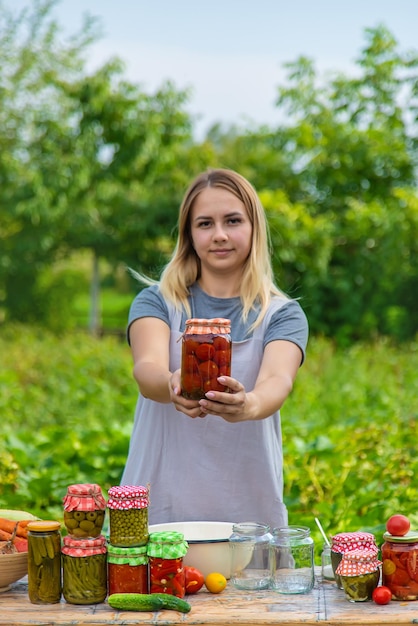 Une femme conserve des légumes dans des bocaux Mise au point sélective