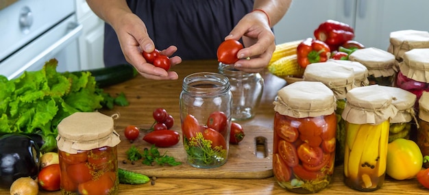 Femme en conserve de légumes dans des pots dans la cuisine Focus sélectif