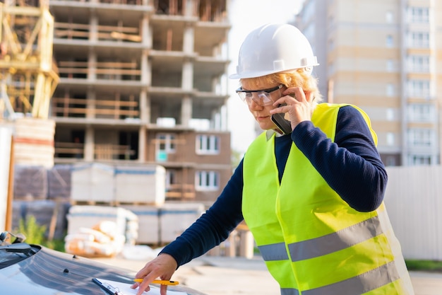 Une femme constructeur sur un chantier de construction inspecte un bâtiment