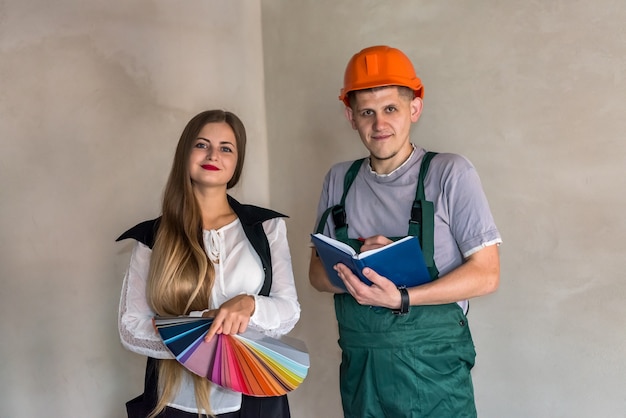 Femme et constructeur choisissant la couleur pour peindre les murs