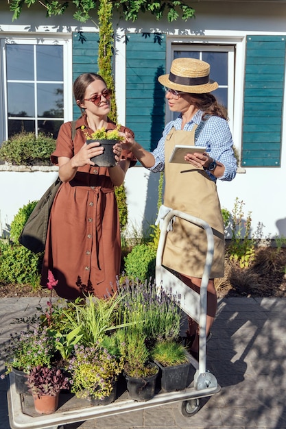 Une femme consulte une jardinière au sujet des plantes avant de les acheter dans une jardinerie