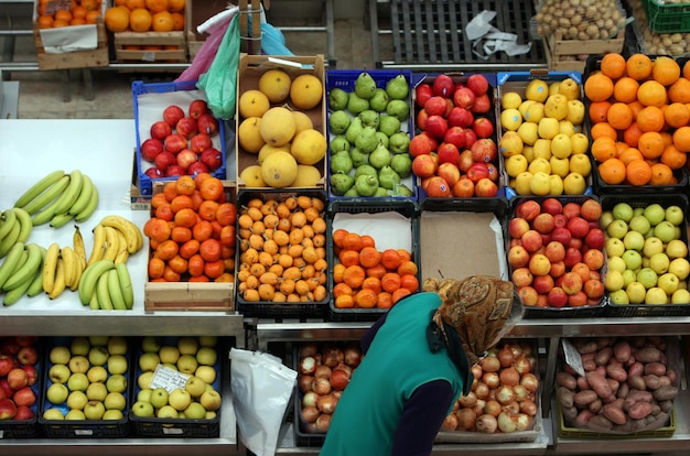Femme contre des fruits dans des caisses au stand du marché