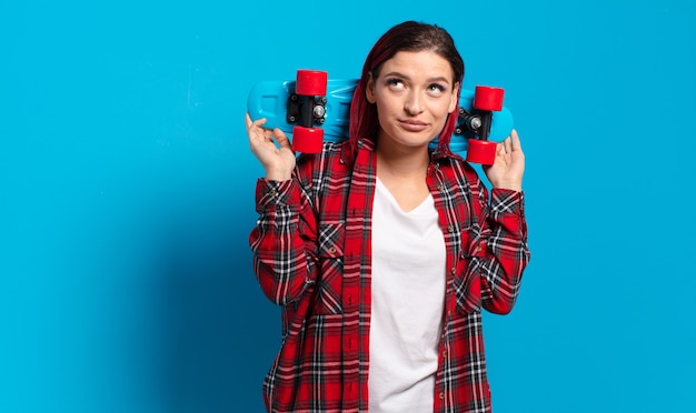 Femme cool cheveux roux avec une planche à roulettes