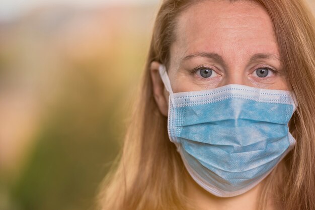 Femme, à, coronavirus, masque protecteur, regarder appareil-photo