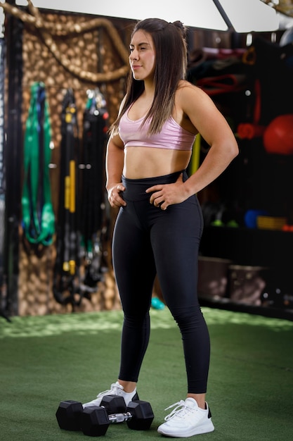 femme avec un corps athlétique posant dans une salle de sport en plein air