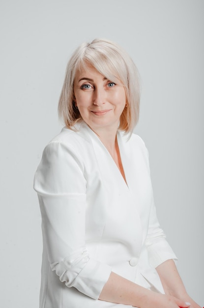 une femme en costume blanc sur fond blanc