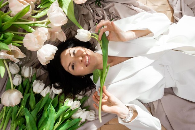 Femme en costume blanc avec des tulipes blanches