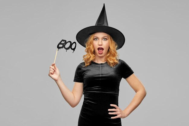 femme en costume d'Halloween de sorcière avec accessoire