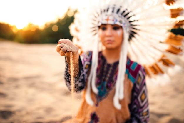 Photo femme en costume d'indien d'amérique au coucher du soleil