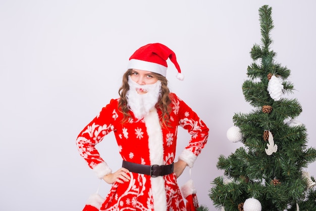 femme en costume de père Noël près de sapin de Noël