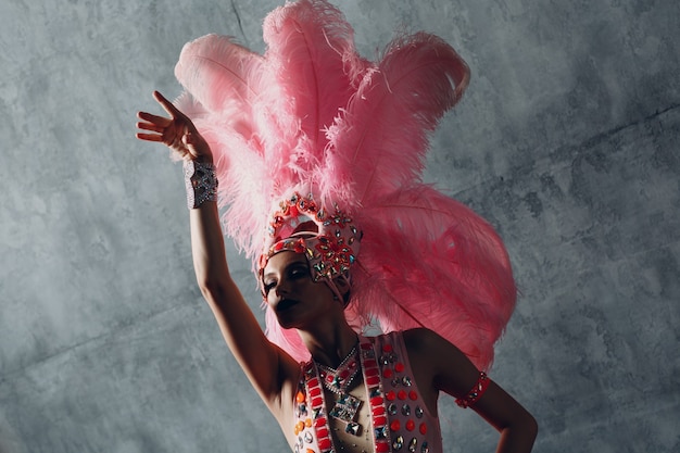 Photo femme en costume de samba ou de lambada au plumage de plumes roses.