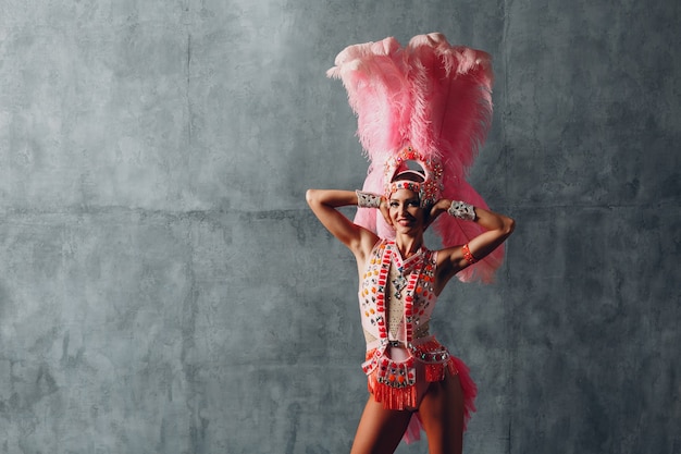 Femme en costume de samba ou de lambada au plumage de plumes roses.