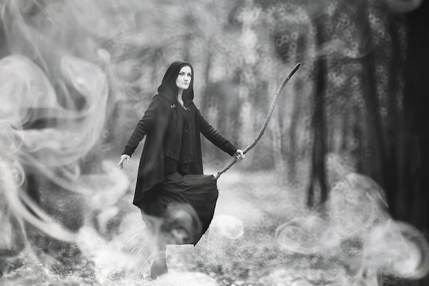 Photo une femme en costume de sorcière dans une forêt dense lors d'un rituel