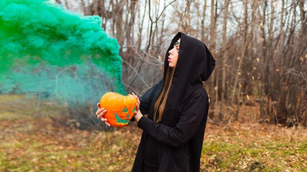 Photo une femme en costume tenant une lanterne soufflant de la fumée à l'extérieur