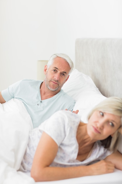 Femme à côté de l&#39;homme au lit à la maison