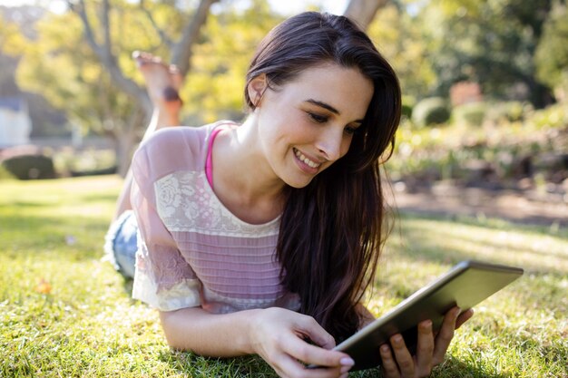 Femme, coucher herbe, et, utilisation, tablette numérique