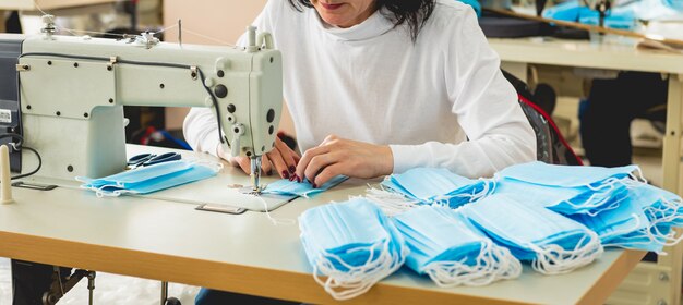 Femme coudre le soin du visage à la machine à coudre.