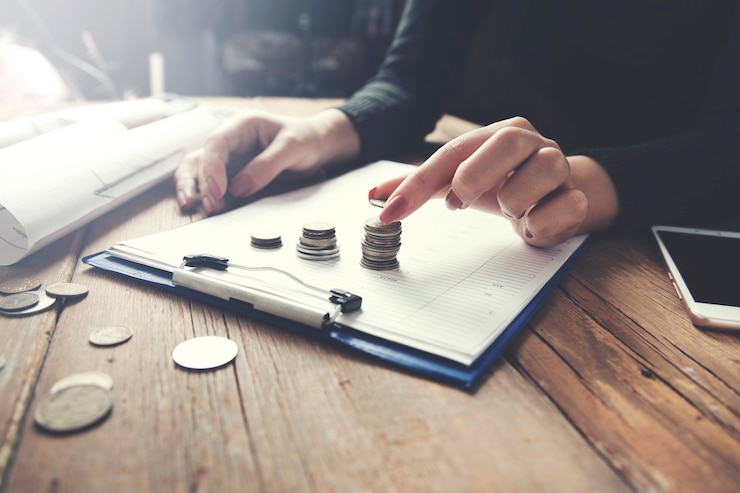 Photo femme countin coins sur un presse-papiers
