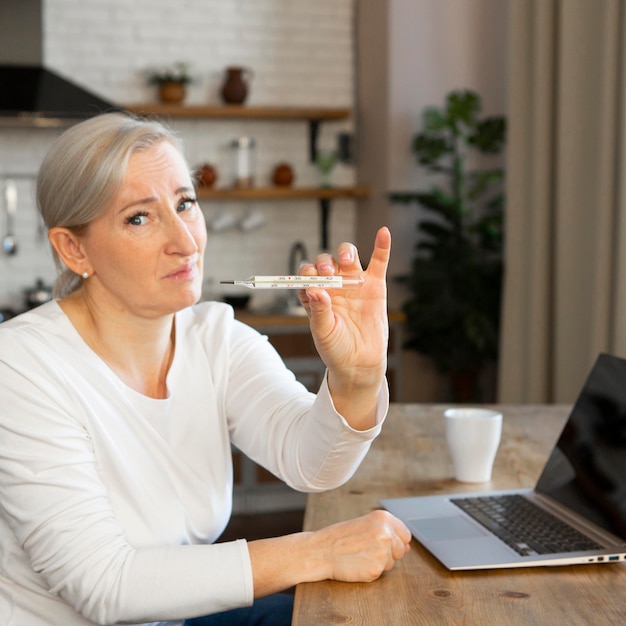 Femme coup moyen avec thermomètre