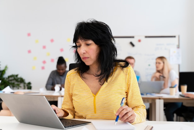 Femme de coup moyen travaillant sur ordinateur portable