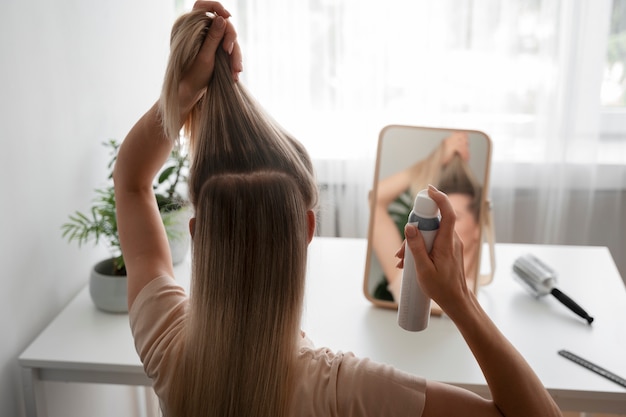 Femme à coup moyen utilisant du shampoing sec à la maison