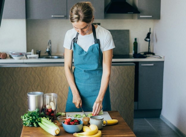Femme coupant des légumes dans la cuisine