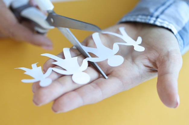 Une femme coupe des figures en papier de la famille avec des ciseaux, des conflits familiaux et un concept de divorce