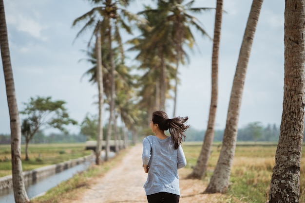 Une femme courait entre les cocotiers