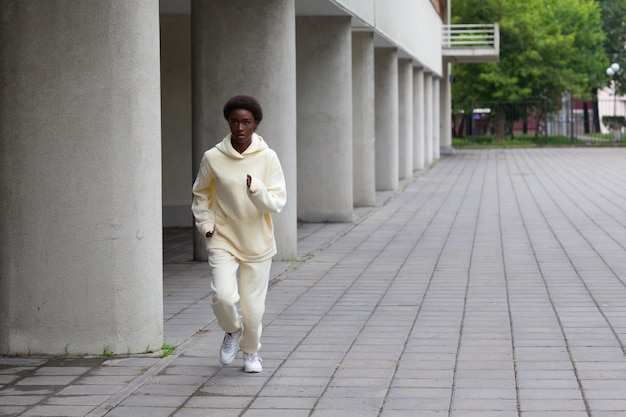 Femme de coureur afro-américaine en sweat à capuche jogging en plein air