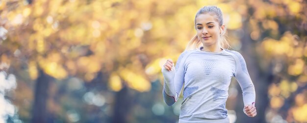 Femme de coureur en automne park tree alley formation en sous-vêtements thermiques de sport.