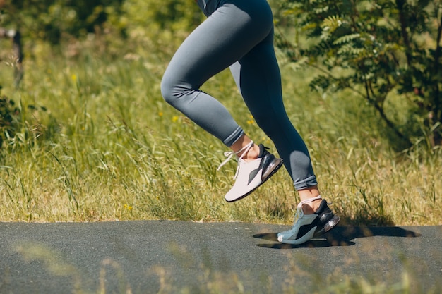 Femme de coureur en chaussures de course gros plan des jambes sportives de la femme. Le jogging féminin.