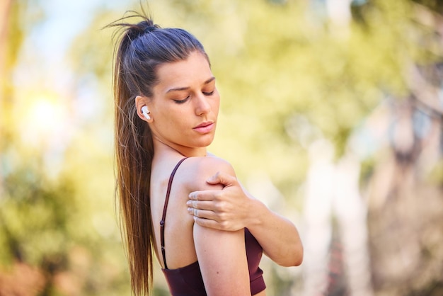 Femme coureuse nature et douleur à l'épaule sur le chemin du parc pour la santé de remise en forme ou se reposer près des arbres pour masser Entraînement en plein air courir et se détendre dans les bois pour les douleurs musculaires problème d'anatomie d'urgence ou entraînement