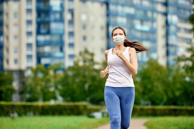 Une femme court avec un masque médical pour se protéger du covid