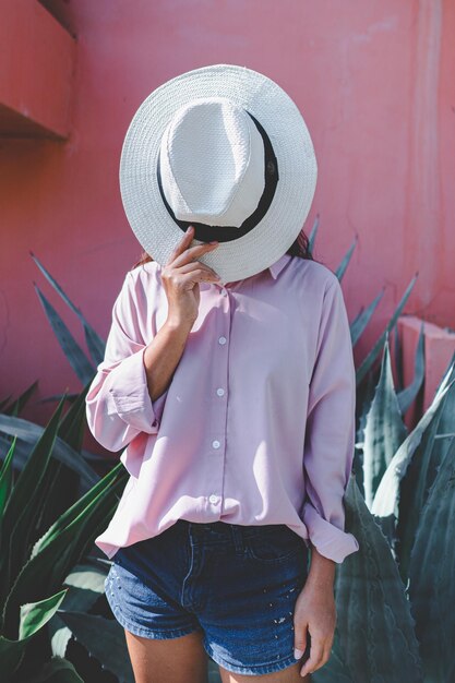 Photo femme couvrant le visage avec un chapeau