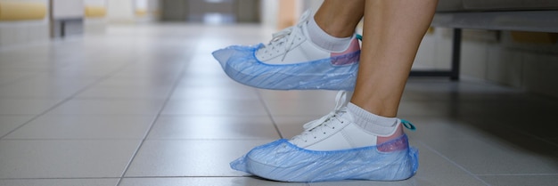 Femme en couvre-chaussures assis dans le couloir de l'hôpital libre