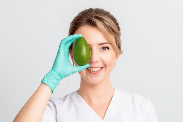 Femme couvre les yeux avec de l'avocat