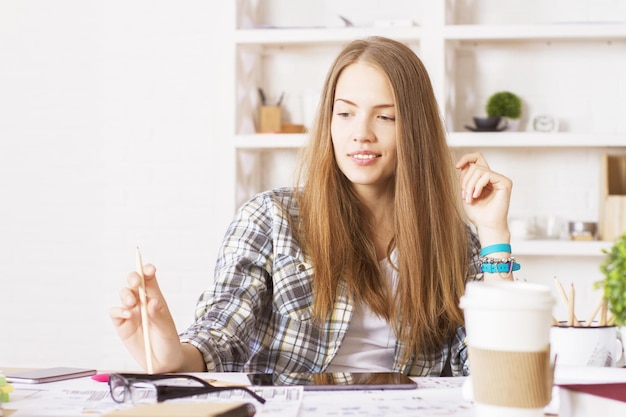 Femme avec un crayon au bureau