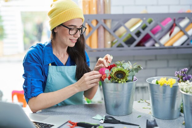 Femme créative organisant des fleurs